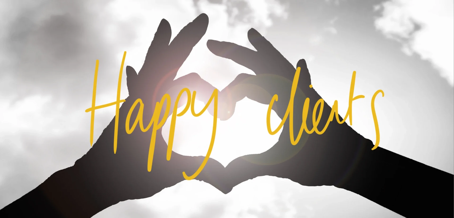 Hands forming a heart shape against the sky
